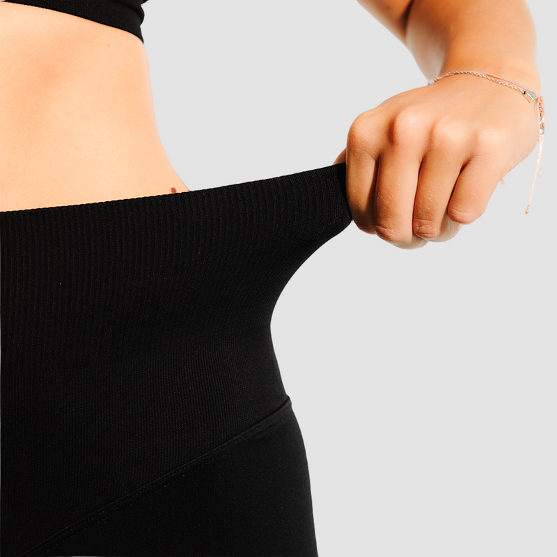 Person stretching a black garment against a white background